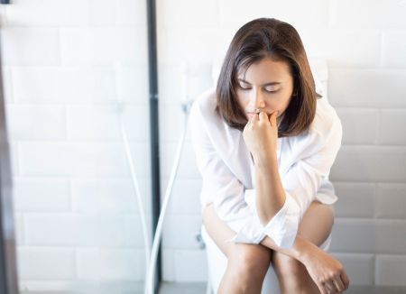 główne_30573186_closeup-woman-sitting-on-toilet-in-the-morning-with-depressed-fe